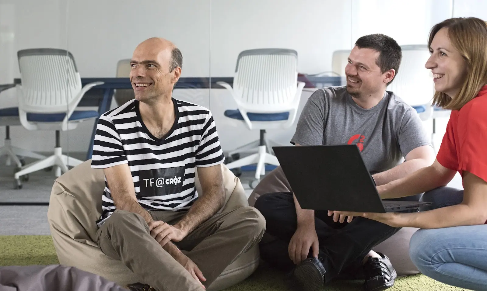 Three CROZ colleagues working together on a laptop in the office